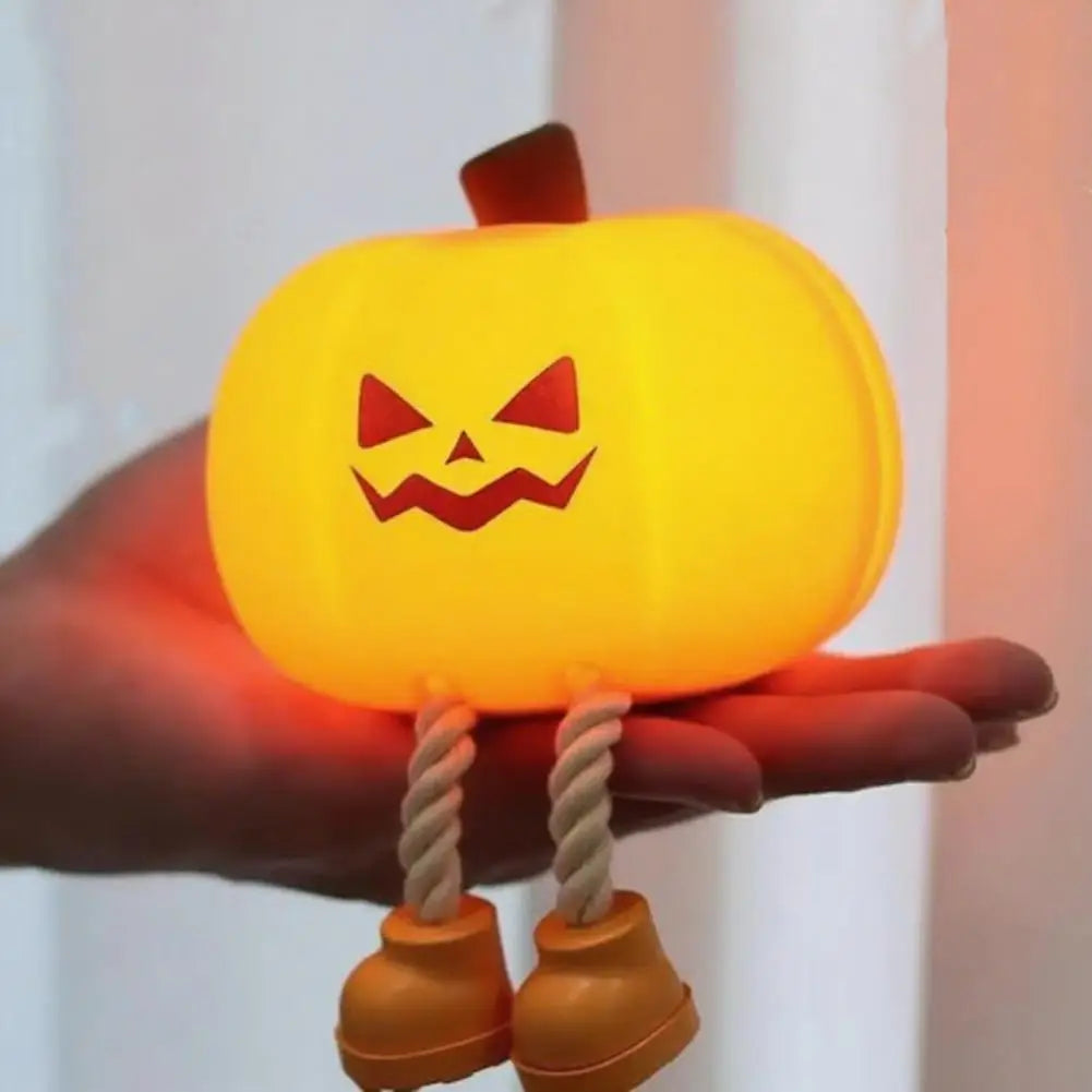 Child squeezes CozyGlow pumpkin night light to dim brightness