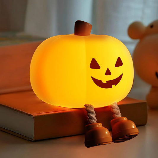 Squishy pumpkin night light glowing on bedside table (CozyGlow)